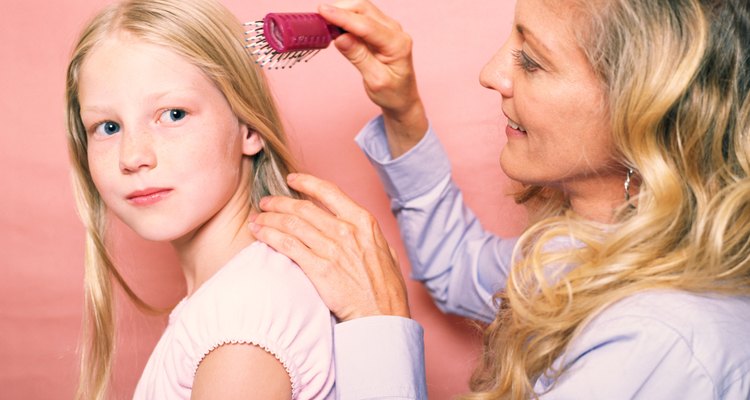 Mother and daughter brushing hair