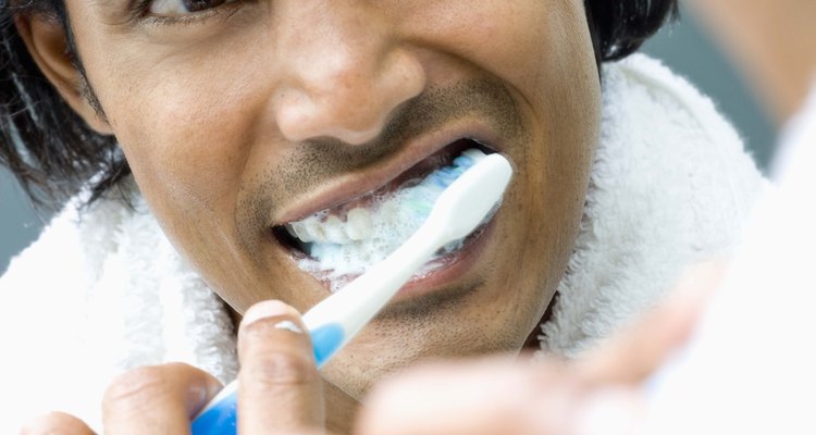 Man brushing teeth in mirror