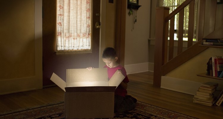 Boy looking into box with light illuminating out