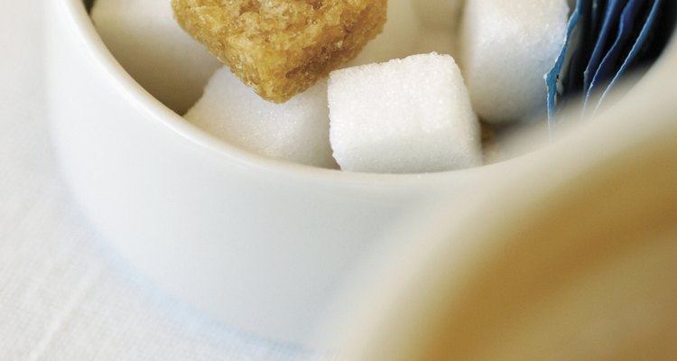 Cubos de açúcar mascavo em meio a cubos de açúcar refinado