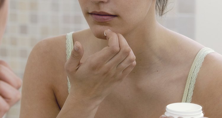 Teenage girl using face cream