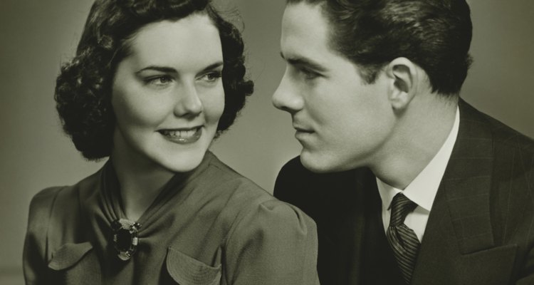 Couple looking in eyes, posing in studio, (B&W), portrait