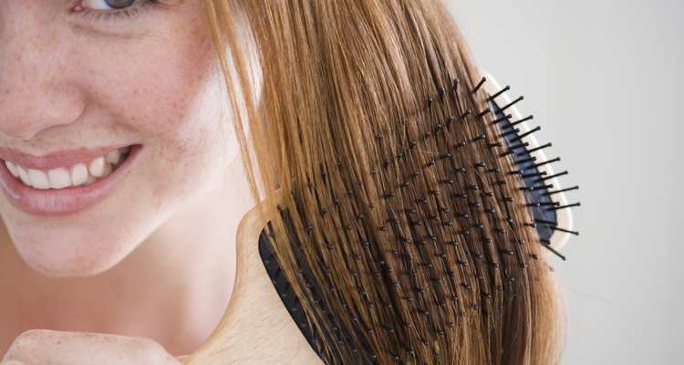 Smiling woman combing her hair