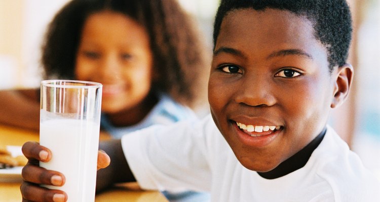 portrait of a young boy (10-14) holding a glass of milk