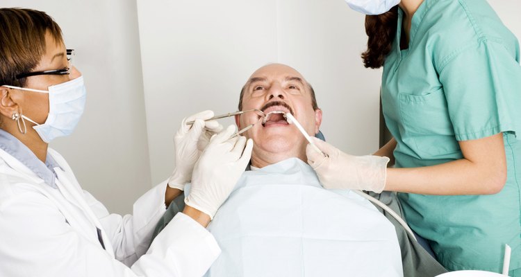 Un asistente dental ayuda al dentista durante un examen.