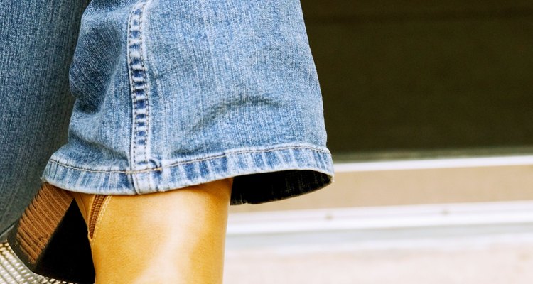 Muestra tus botas enrollando tus jeans de manera ajustada alrededor de tus tobillos.