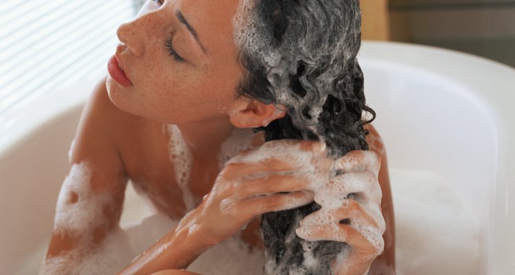 Woman washing hair in bubble bath