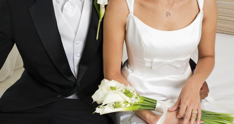 Bride holding bouquet beside groom