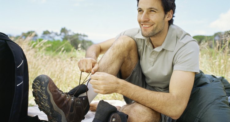 Hombre atando sus botas de senderismo ecológicas