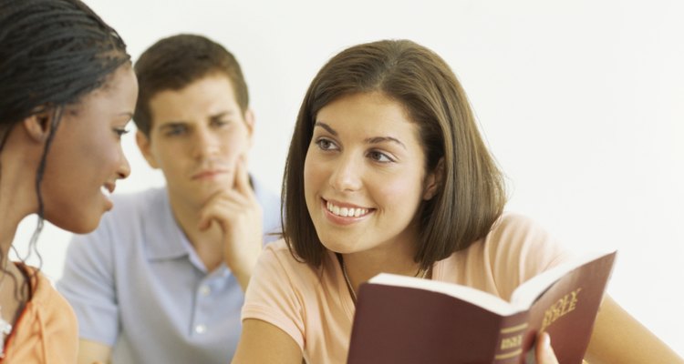 two teenage girls discussing the bible in a classroom