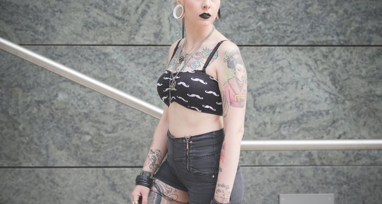 Portrait of young female tattooed punk on subway stairs