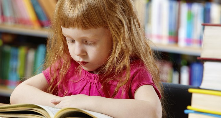 Una pequeña niña leyendo en la biblioteca.