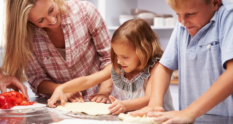 Mother preparing pizza with kids