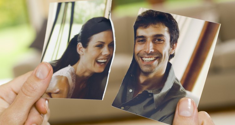 Hands with torn photograph of couple