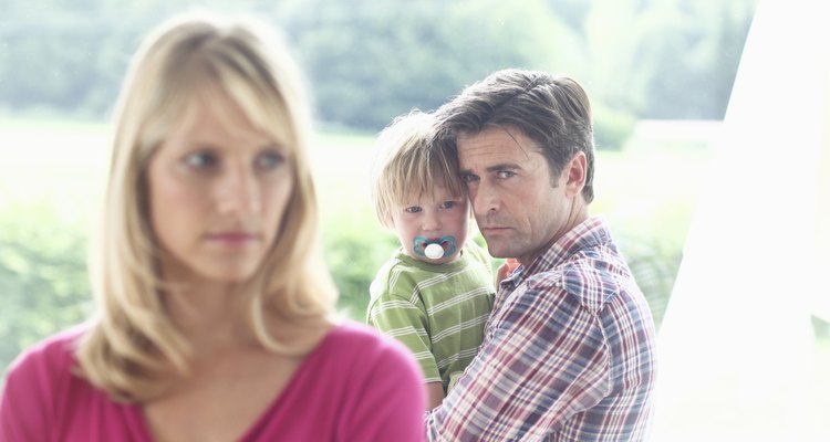 Mature man holding son and looking at woman in foreground