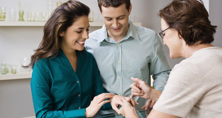 Jeweler assisting couple with rings