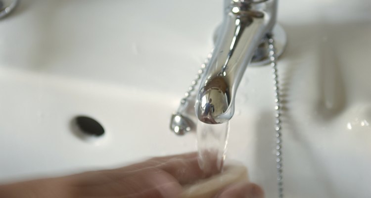 Person washing hands under running tap 
