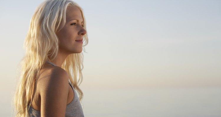 Young woman standing on beach, side view