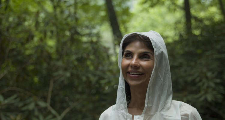 Close-up of mature woman in white raincoat, smiling