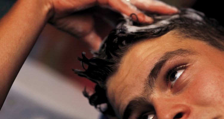 close-up of hands washing a man's head