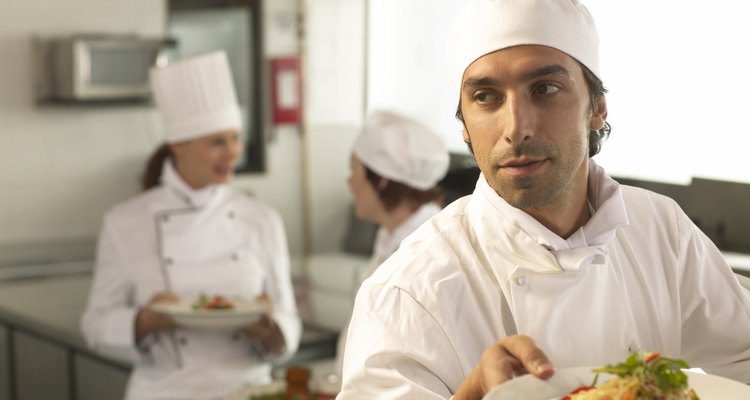 Un joven chef prepara un plato en una cocina