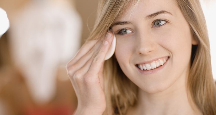 Teenage girl removing eye makeup