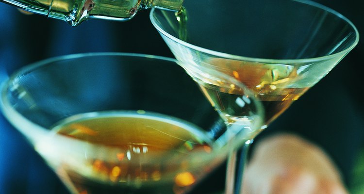 Close up of a Waiter Pouring Brandy into Cocktail Glasses