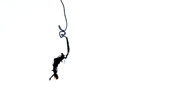 Silhouette of a bungee jumping woman isolated on white background