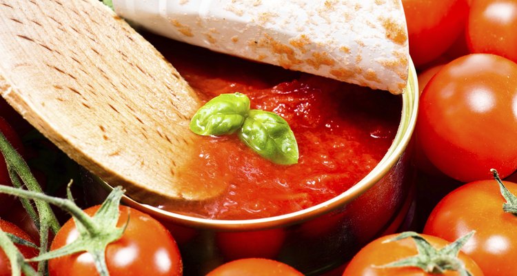 wooden spoon with tomato salsa and a basil leaf