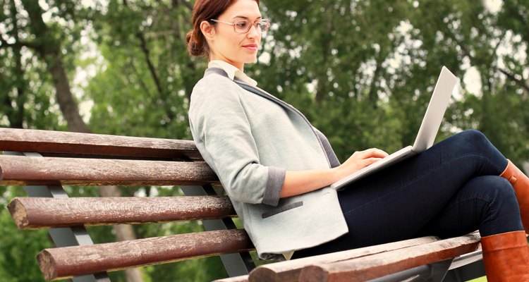 Woman in park with laptop