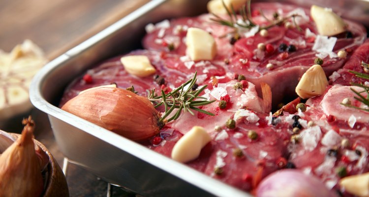 Closeup meat steel pan with spices ready to cook table