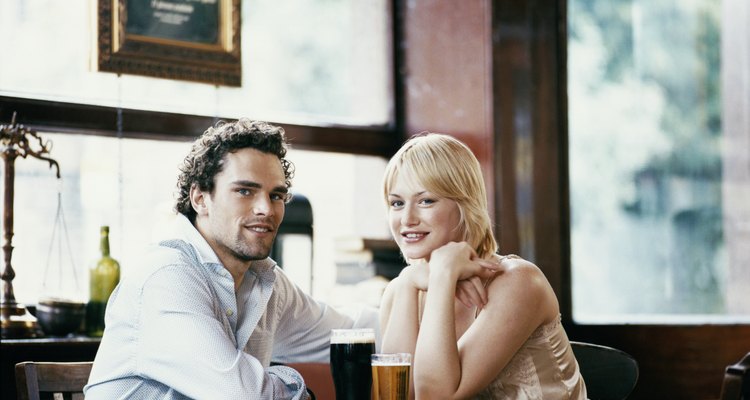 Couple Sitting at a Table in a Pub Drinking and Chatting