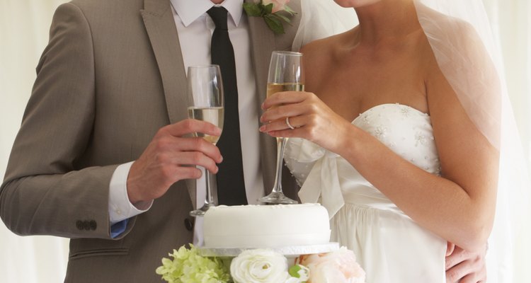 Bride And Groom With Cake Drinking Champagne At Reception