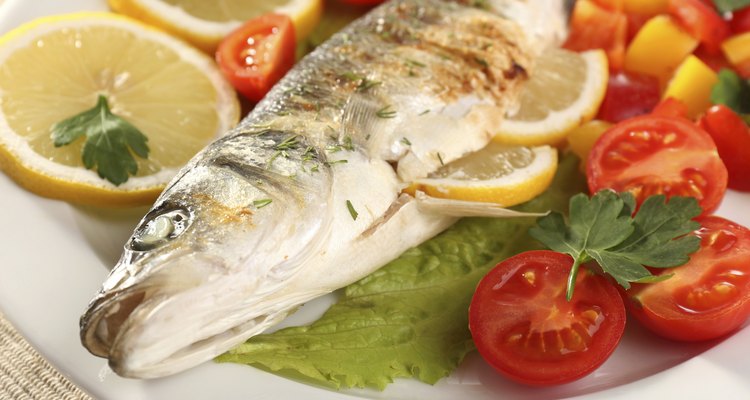 Delicious grilled fish on plate on table close-up