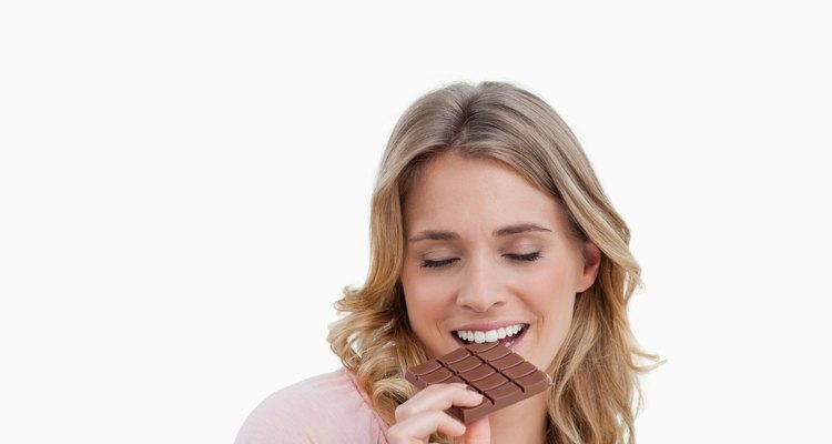 Young woman eating a delicious peace of chocolate