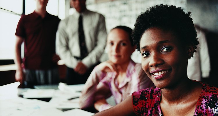 Portrait of a Fashion Designer Sitting in Front of Three of Her Colleagues at a Desk