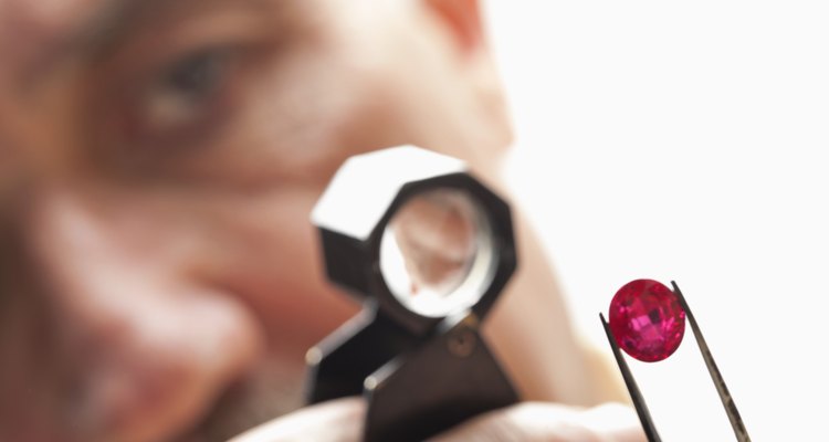 Close up of gemstone with jeweler looking through magnifying glass