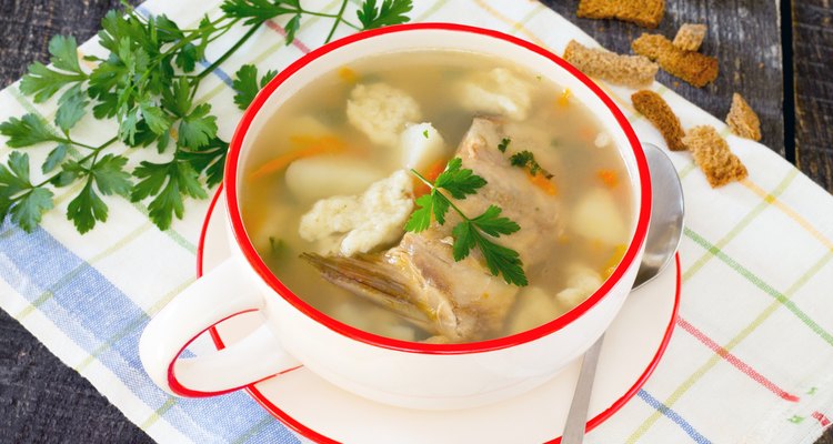 Soup with fresh fish and dumplings on a wooden table