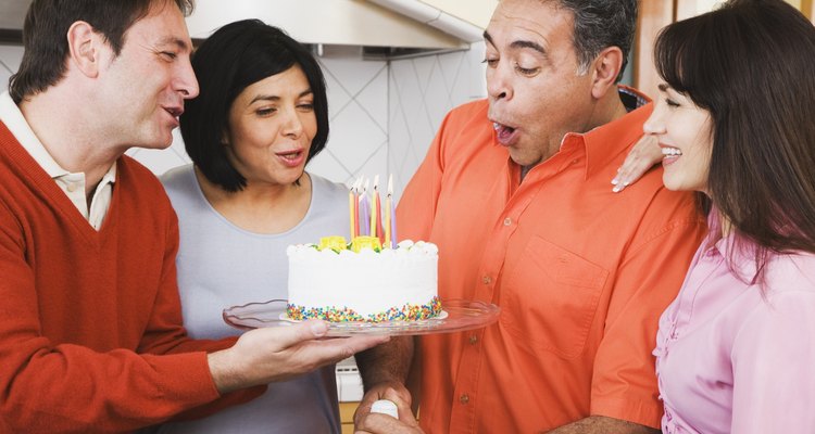 Middle-aged Hispanic man blowing out birthday candles