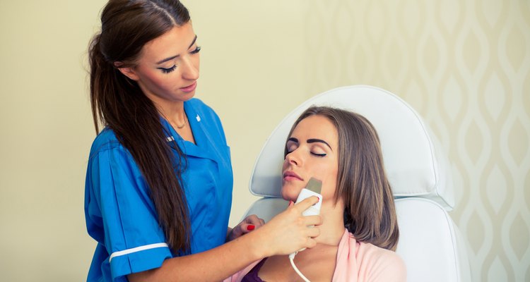 Picture of pretty beautician doing microdermabrasion procedure.