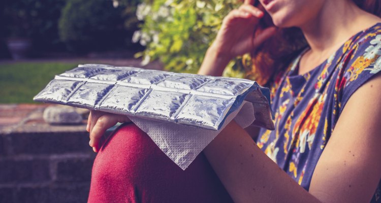 Young woman with cold pack on injured hand