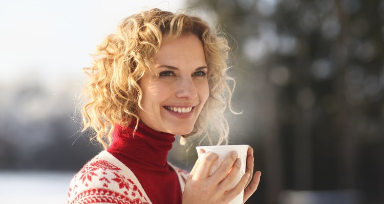 Mid adult woman holding cup outdoors in snow