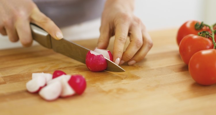 Closeup on woman cutting radishes