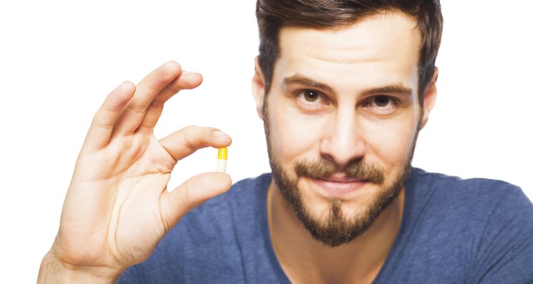 Handsome man showing pills