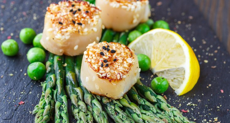 Fried scallops with sesame seeds, asparagus  and  lemon