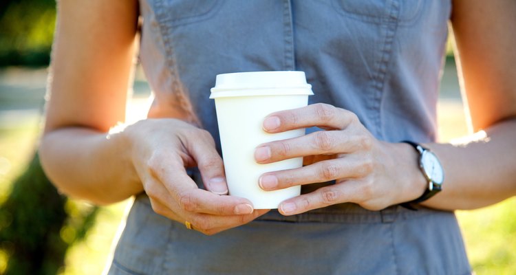 disposable cup of coffee in hand