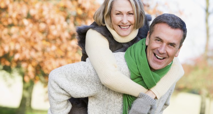 Senior man giving woman piggyback ride