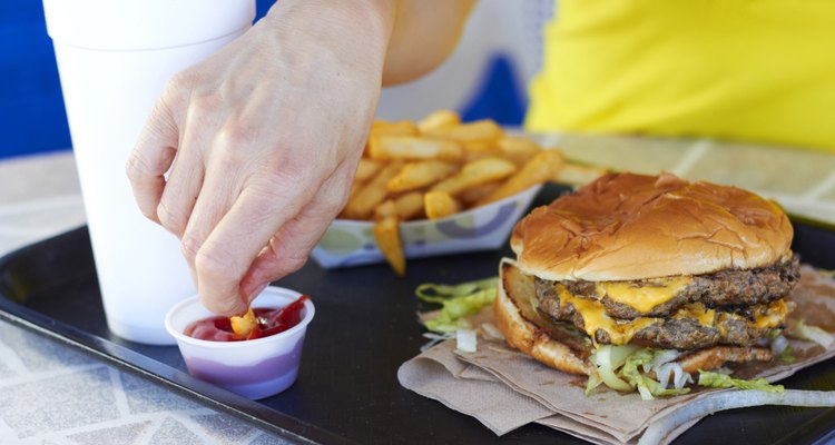 Female Hand Dipping Fries In Tomato Sauce