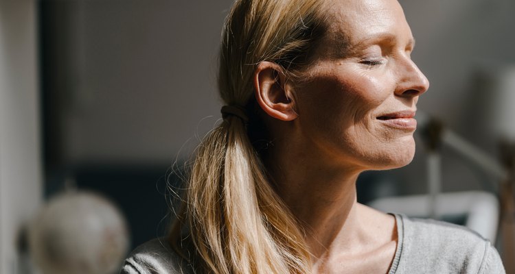 middle-aged woman smiling peacefully with eyes closed