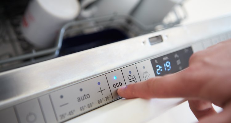 Close Up Of Man Setting Economy Cycle On Dishwasher